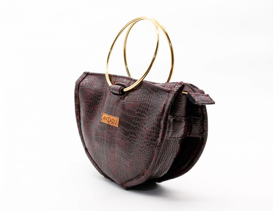 Bolso Aduany Mini visto de forma lateral, piel vegana, color granate, detalle artesanal y diseño funcional